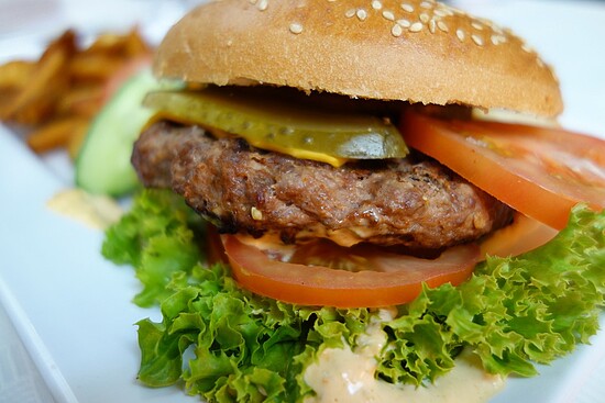 Juicy classic burger with cheddar, fresh veggies, and crispy fries—pure comfort food delight.