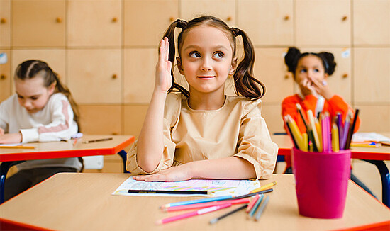 Engaged girls in a colorful classroom, showcasing participation, creativity, and focused learning.