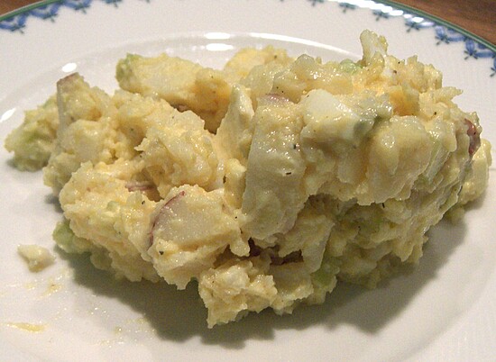 Creamy potato salad with egg and celery, elegantly served, perfect for picnics and gatherings.