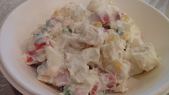 Creamy vegetable salad with colorful peppers, peas, and corn in a rich mayonnaise dressing.