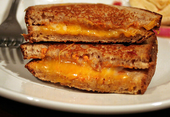 Delicious grilled cheese sandwich with gooey cheddar, crispy whole grain bread, and inviting presentation.