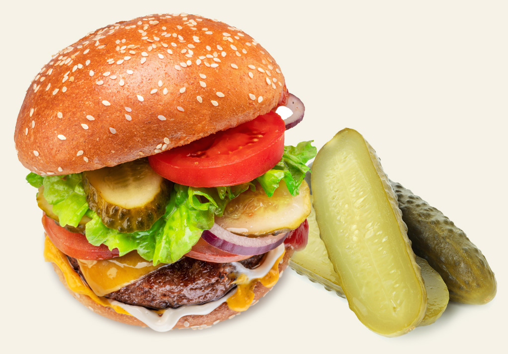 Mouth-watering hamburger with melted cheese, fresh toppings, and crispy pickles on the side.