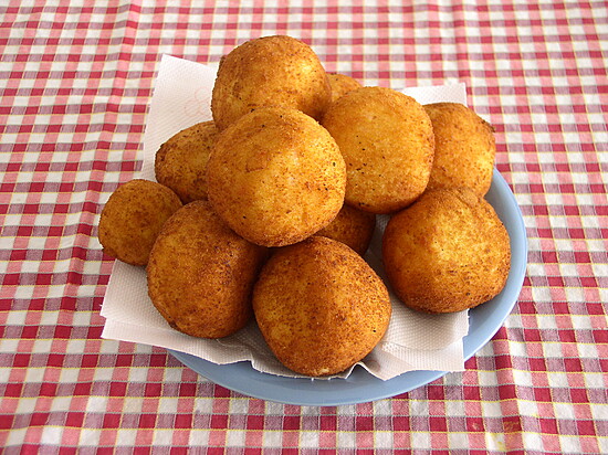 Golden-brown homemade fried snacks on a blue plate atop a cozy checkered tablecloth.