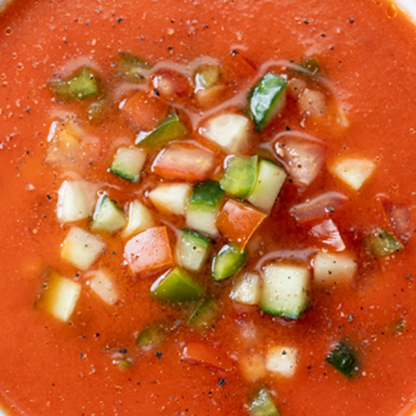 Vibrant hearty tomato soup with fresh diced vegetables, perfect for a comforting meal.