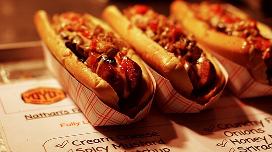 Gourmet hot dogs topped with vibrant condiments, nestled in toasted buns, perfect for street food lovers.