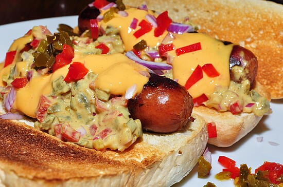 Loaded hot dogs topped with melted cheese, fresh veggies, and served on toasted bread.