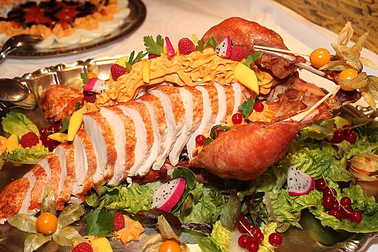 Stunning roasted lobster centerpiece with vibrant fruit garnishes and rich orange sauce.