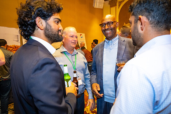 Engaged professionals networking at a lively conference event, enjoying conversation and beverages.