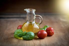 Golden olive oil, ripe tomatoes, and fresh basil in a rustic kitchen setting.