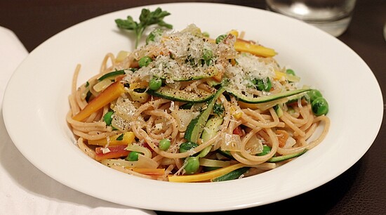 Whole grain vegetable spaghetti with zucchini, bell peppers, peas, and Parmesan in a light, fresh dish.