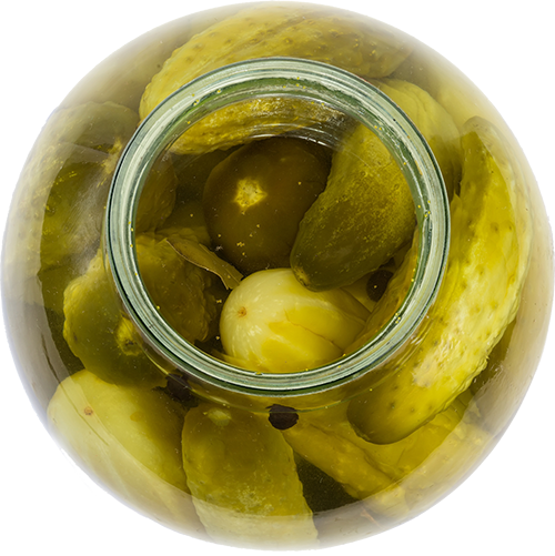 Glass jar filled with assorted pickles in brine, showcasing vibrant colors and textures.