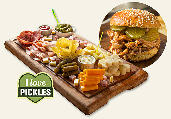 Colorful charcuterie board featuring pickles, meats, cheeses, and a delicious burger.