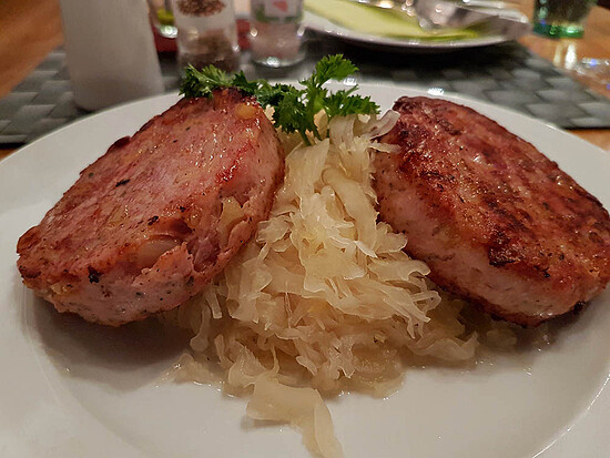 Sizzling sausage served with tangy sauerkraut, a classic comfort food dish.