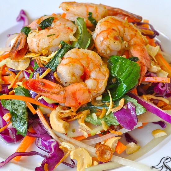 Vibrant shrimp salad with fresh vegetables, cashews, and crispy onions for a tasty, refreshing meal.