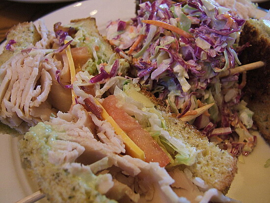 Toasted turkey sandwich with colorful coleslaw, featuring fresh ingredients and inviting presentation.