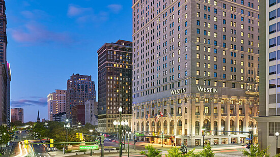 Twilight city scene featuring the Westin Hotel and vibrant urban activity.