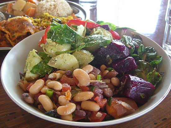 Colorful salad bowl featuring fresh greens, beans, and diced vegetables for a nutritious meal.