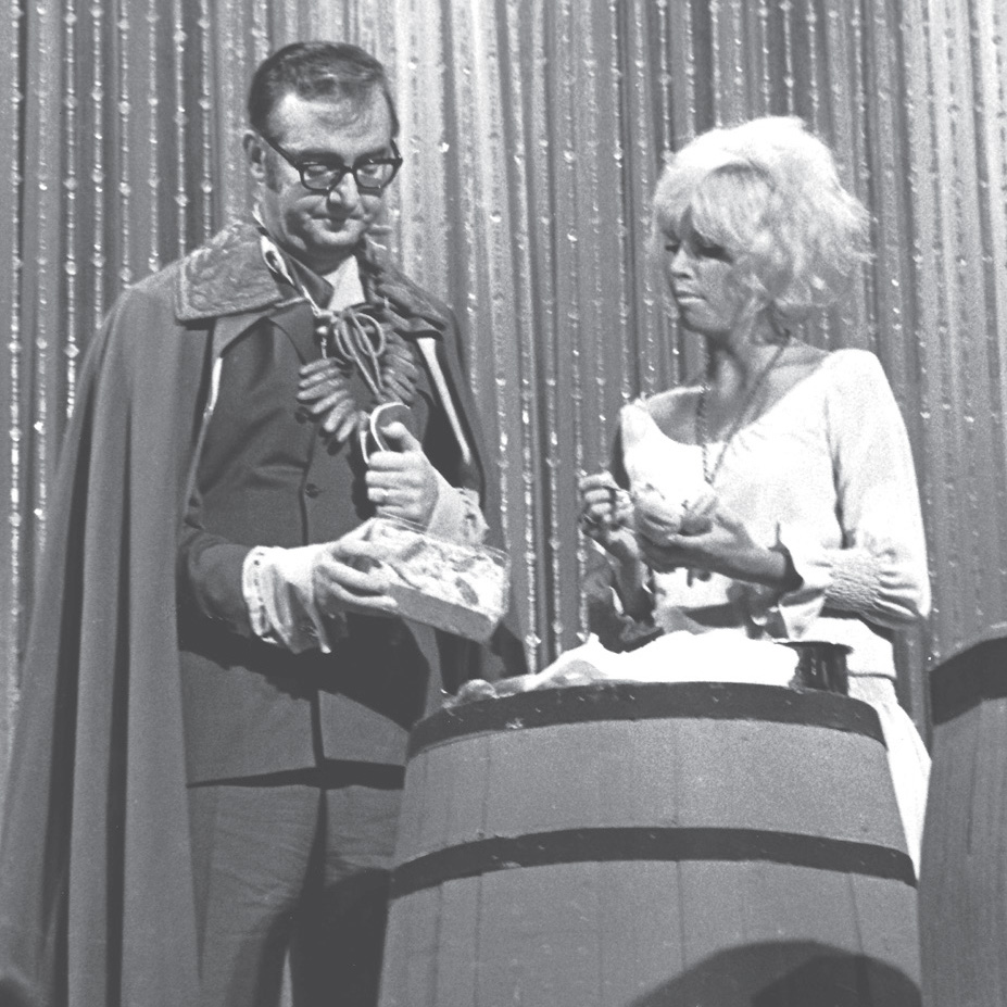 Vintage television performance featuring a man in a suit and a woman in a white gown.